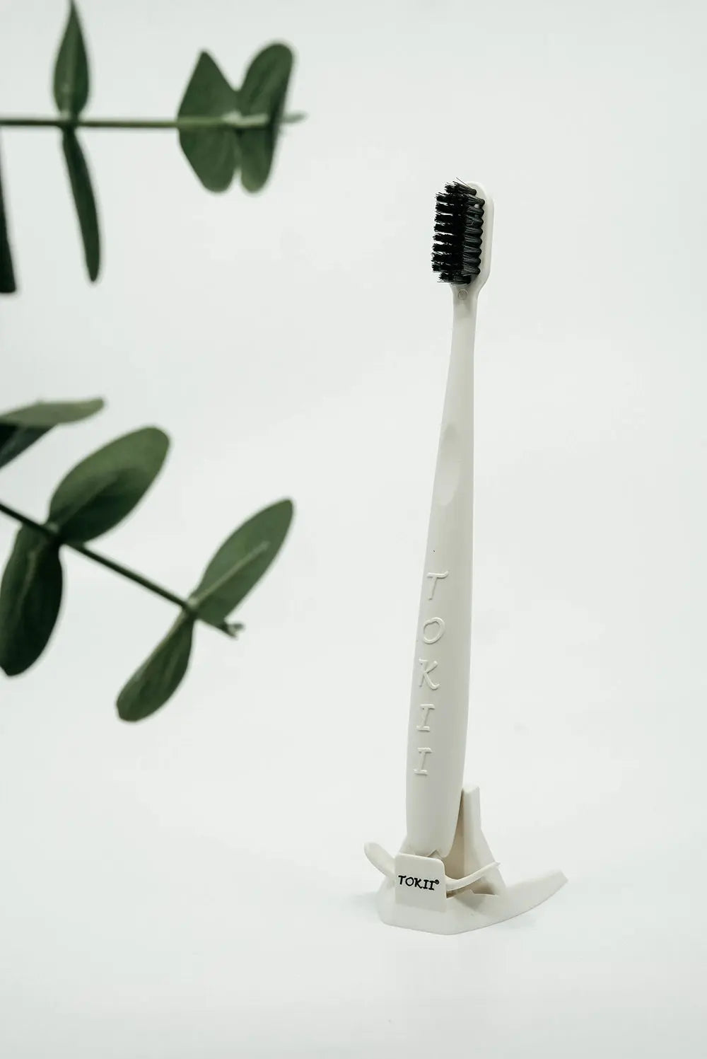 Tokii white bamboo bristle toothbrush with sliding tongue scraper