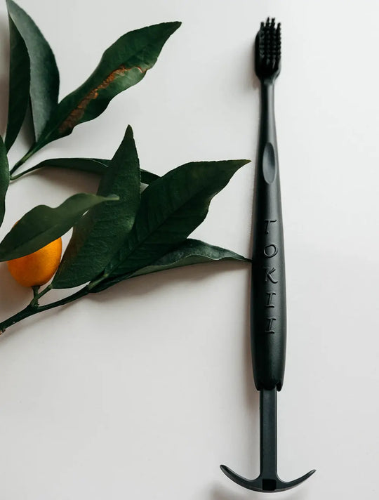 Tokii black bamboo bristle toothbrush with sliding tongue scraper