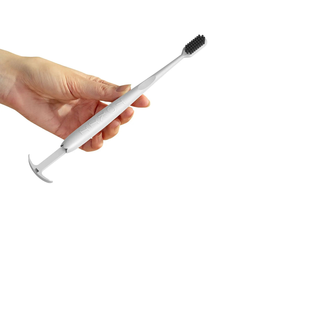 Tokii white bamboo bristle toothbrush with sliding tongue scraper